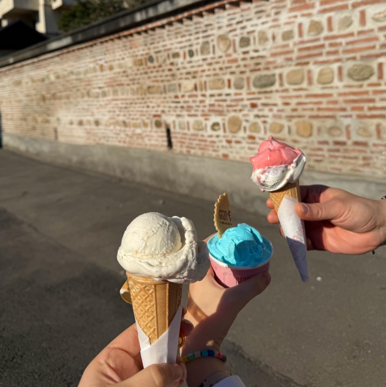 A group of hands holding ice cream conesAI-generated content may be incorrect.