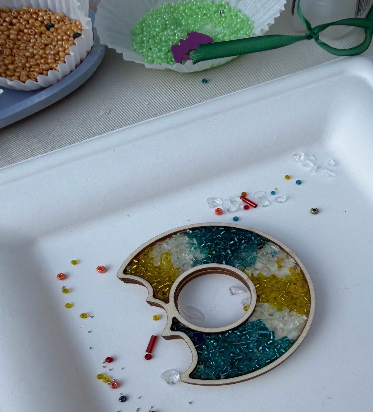 A white foam container with a round object with colorful beadsAI-generated content may be incorrect.