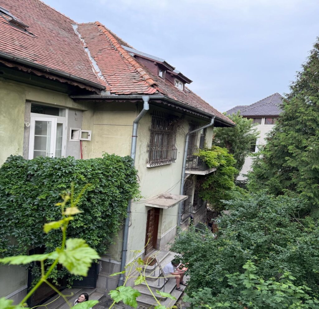 A building with trees and bushes AI-generated content may be incorrect.