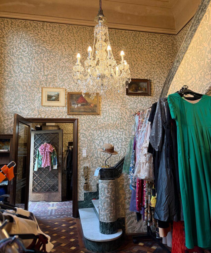 A room with a chandelier and clothes AI-generated content may be incorrect.